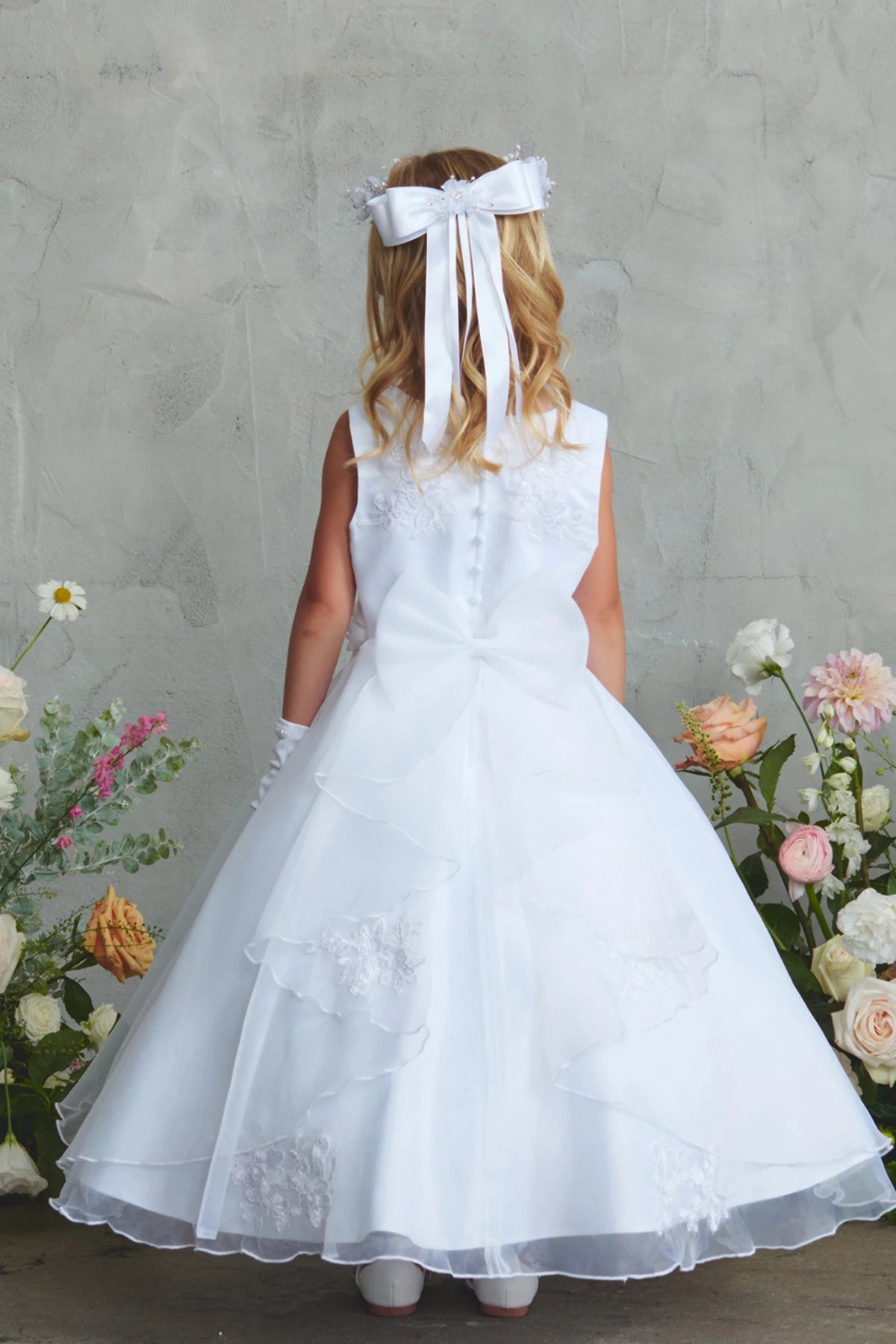 On this white flower girl dress, layered overskirt is visible.