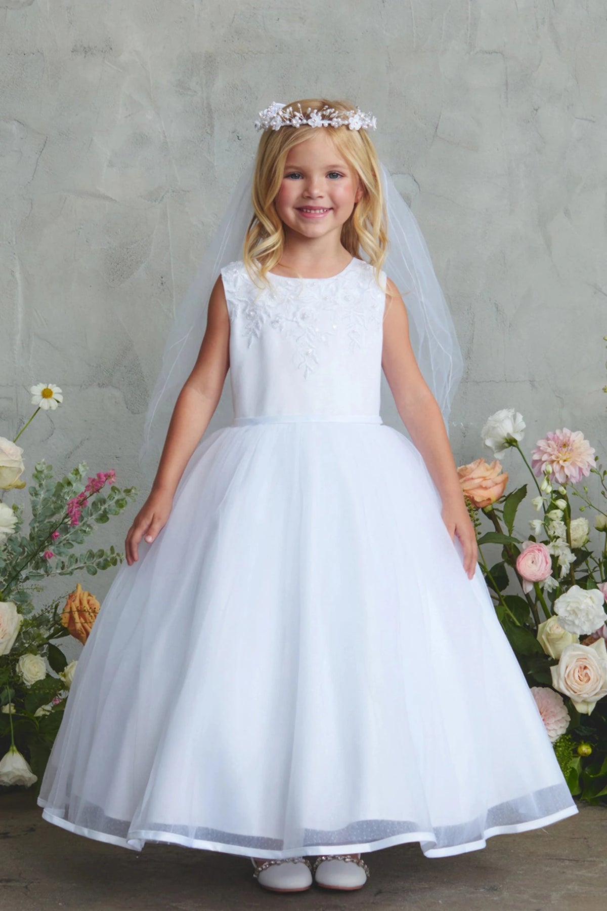 Detailed with a full satin skirt, this white flower girl dress.