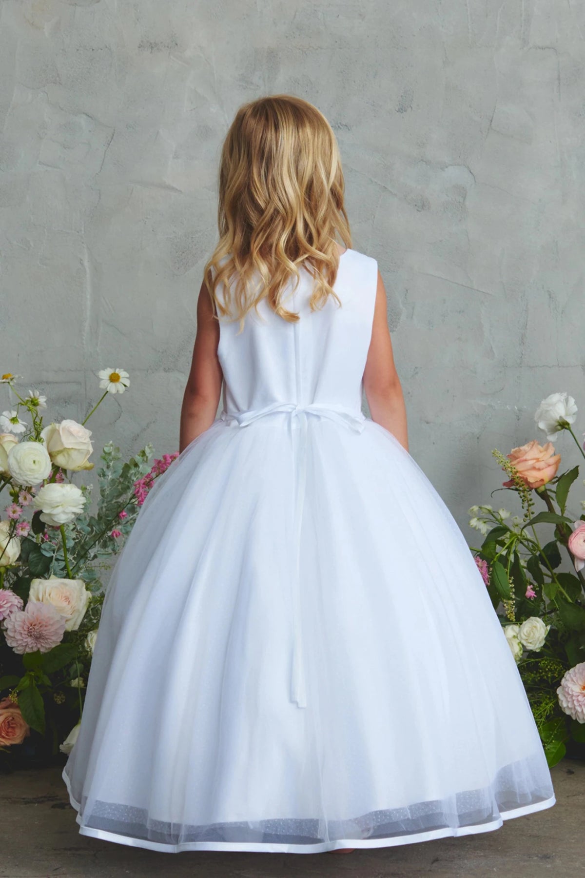 Featuring a small satin back ribbon, a white flower girl dress.