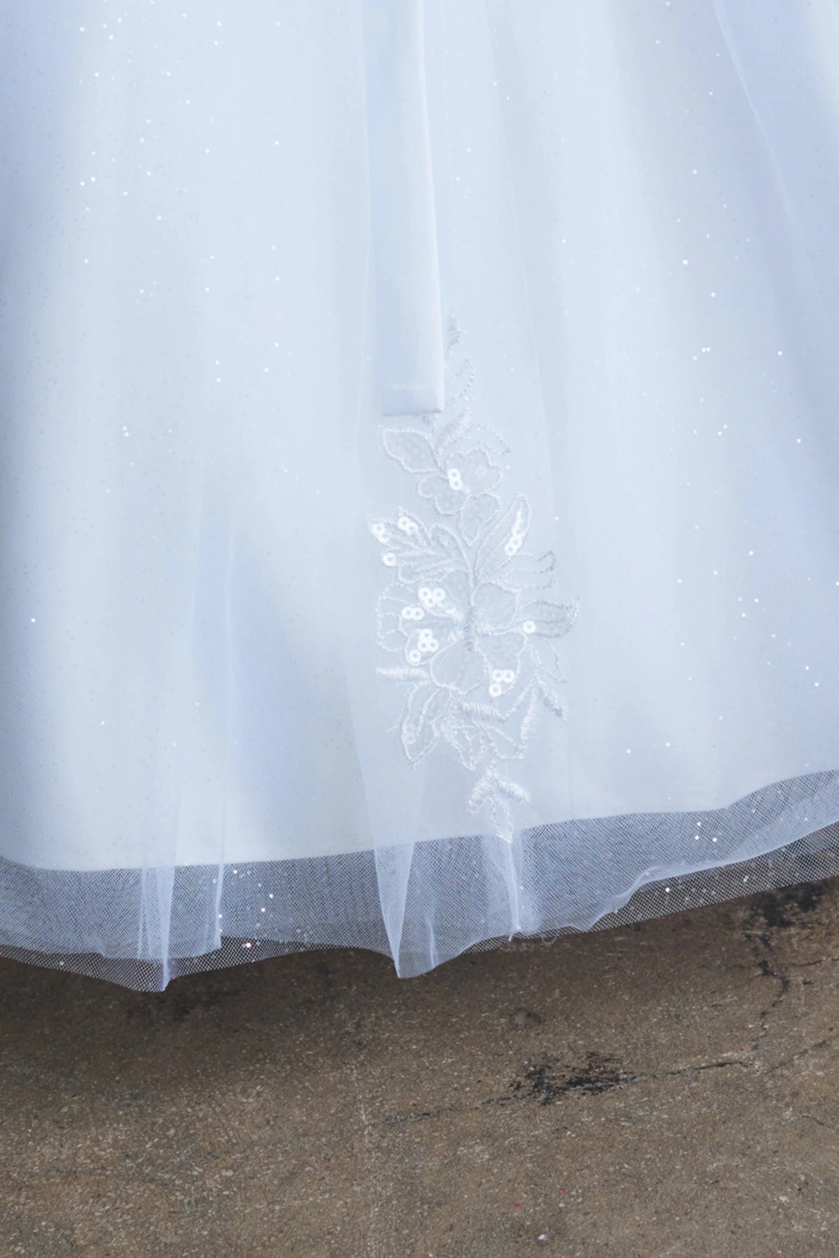 Scattered skirt flowers are visible on the white flower girl dress.