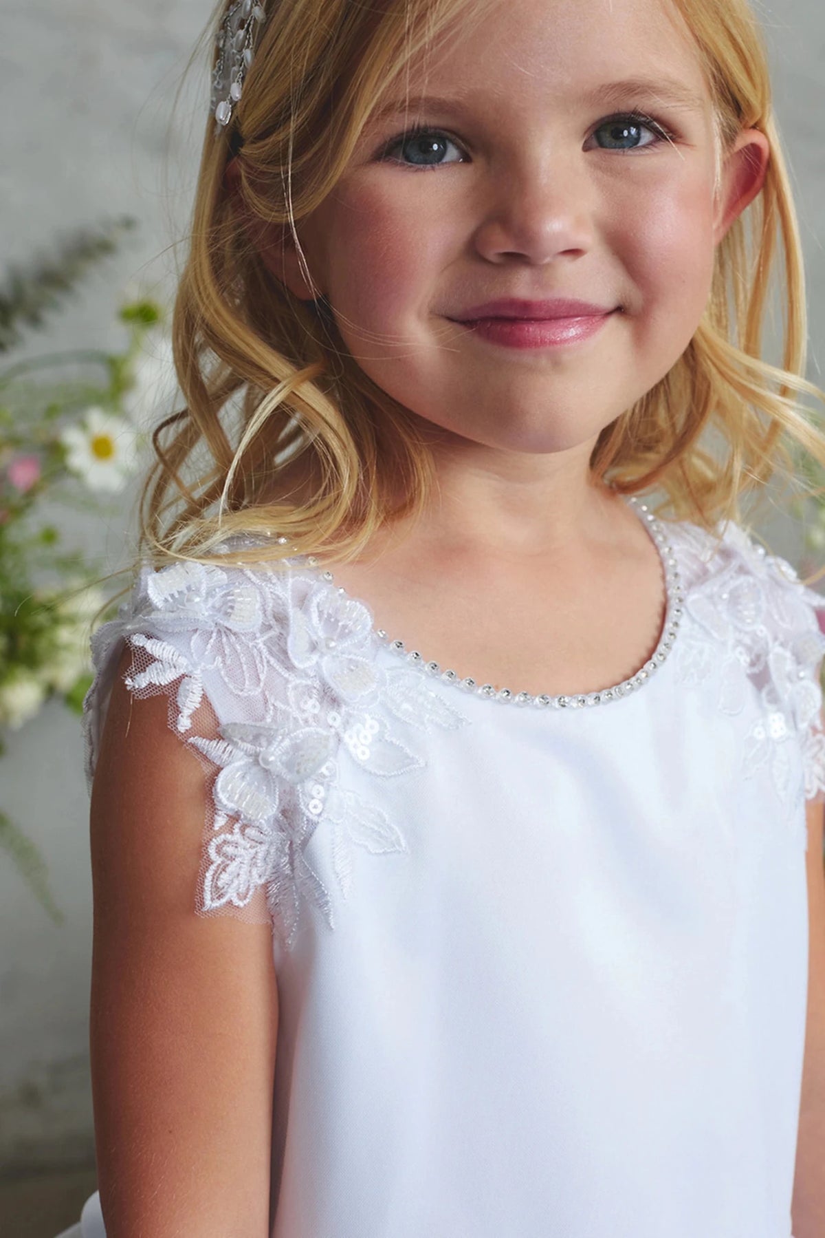 Pearl-trimmed neckline shown on the white flower girl dress.
