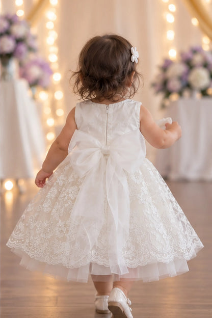 Back view of the ivory flower girl dress reveals a large bow and zipper.