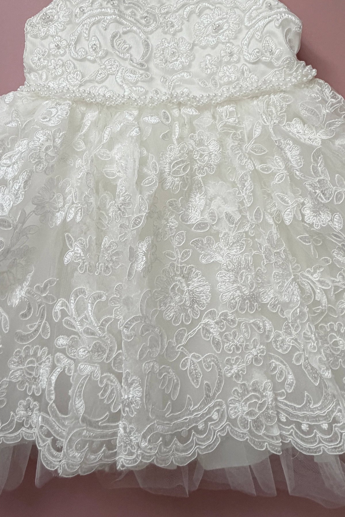 Scalloped floral lace edges the skirt of this ivory flower girl dress.