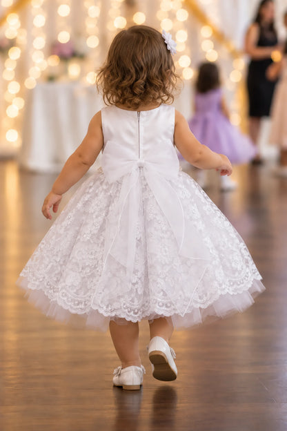 Rear zipper and large bow finish the white flower girl dress.