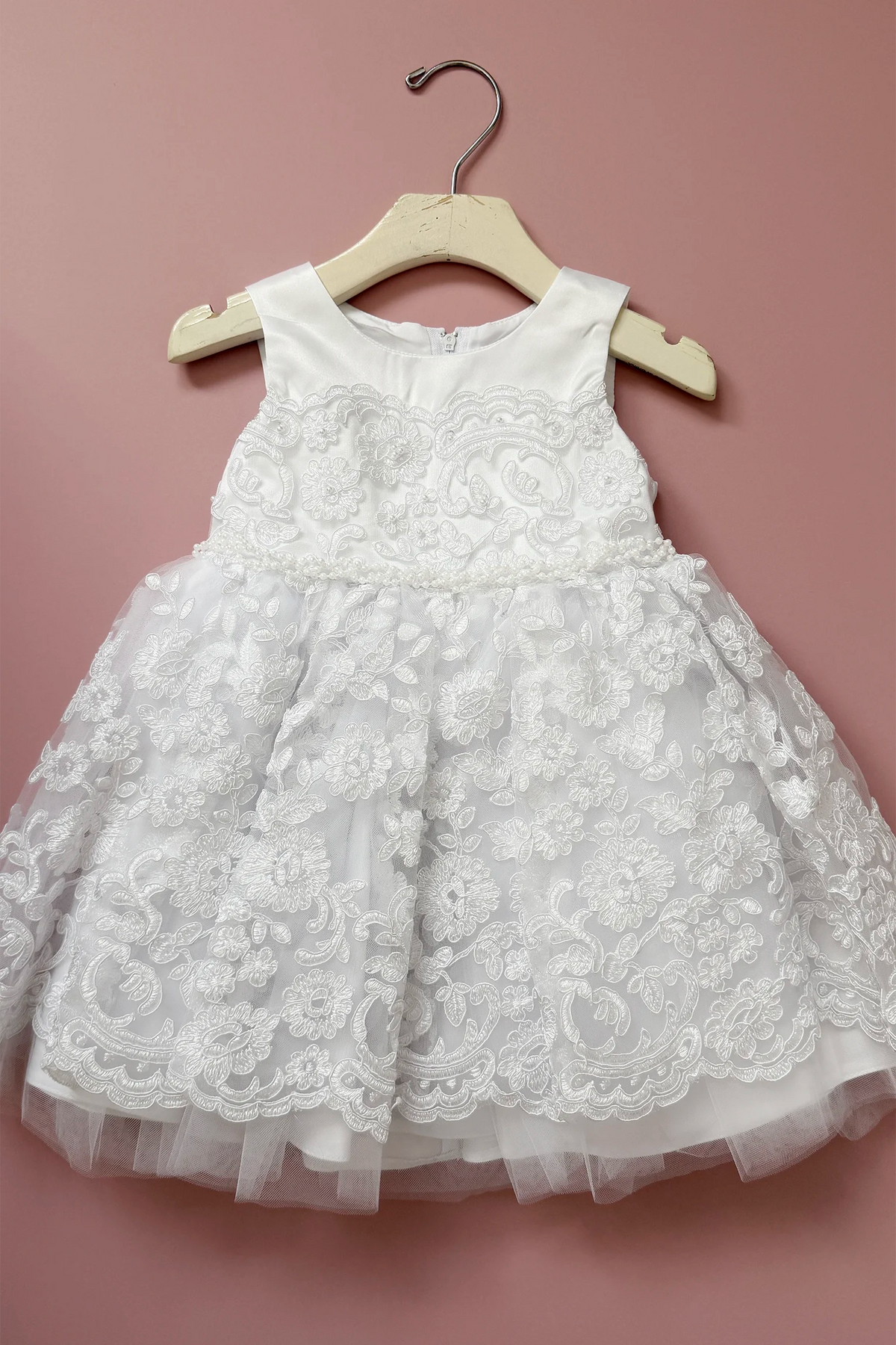 Floral lace covers the flared skirt of this white flower girl dress.