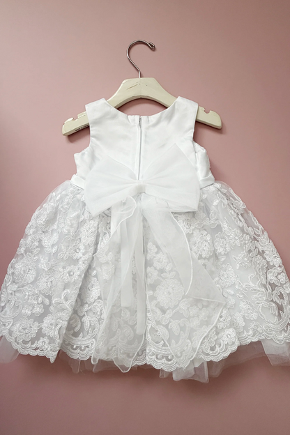 Sheer bow tails extend over the white flower girl dress skirt.