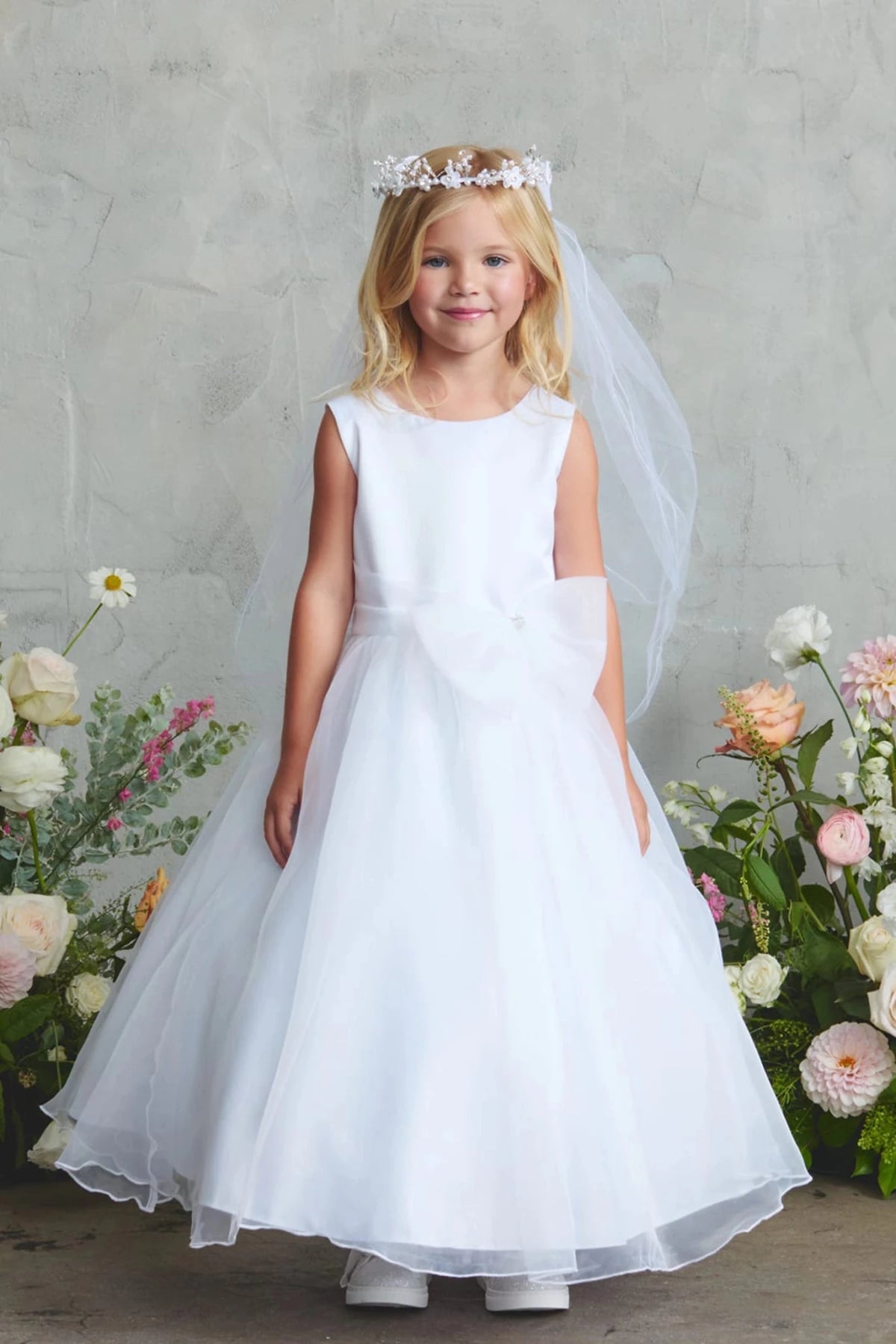 On this white flower girl dress, a full satin skirt is visible.