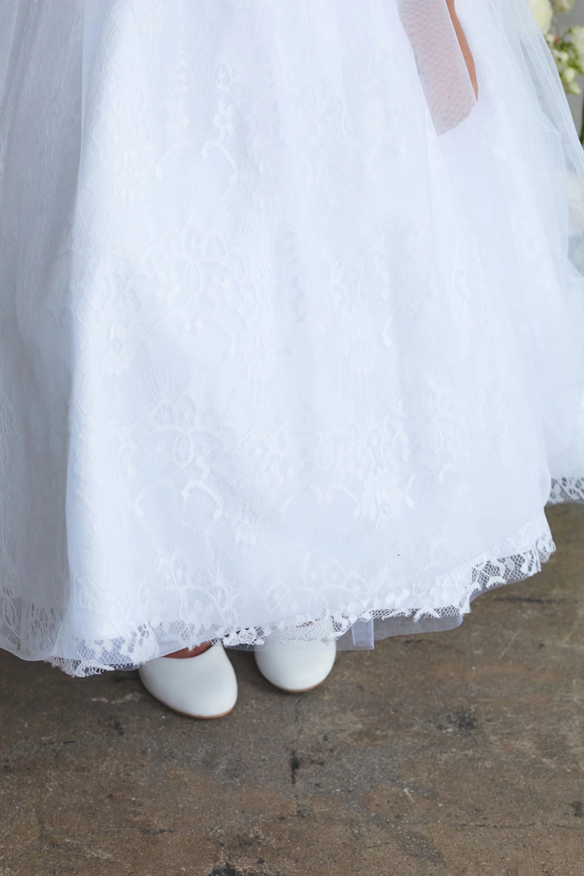 Scalloped floral hem on a white flower girl dress.