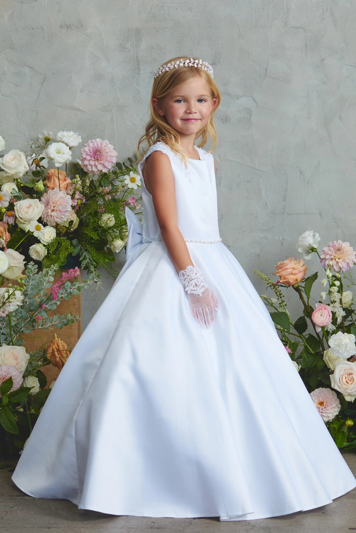Focus on a flowing satin skirt of the white flower girl dress.