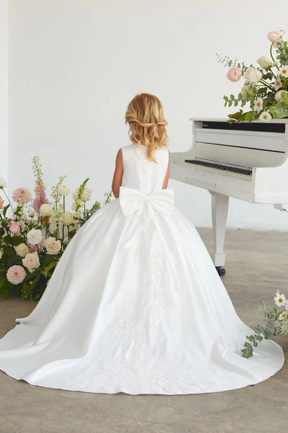 Focus on a long lace-trimmed train of the white flower girl dress.