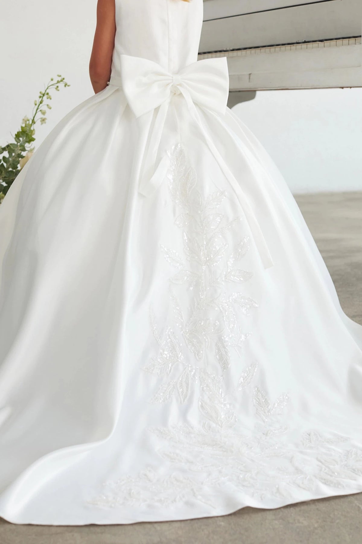 Lace-edged back train accents this white flower girl dress.
