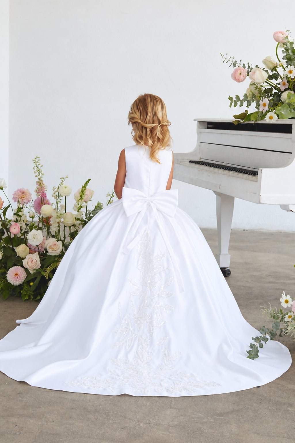 Back view of Tiptop 5925 white satin flower girl dress with a large bow and beaded floral train.