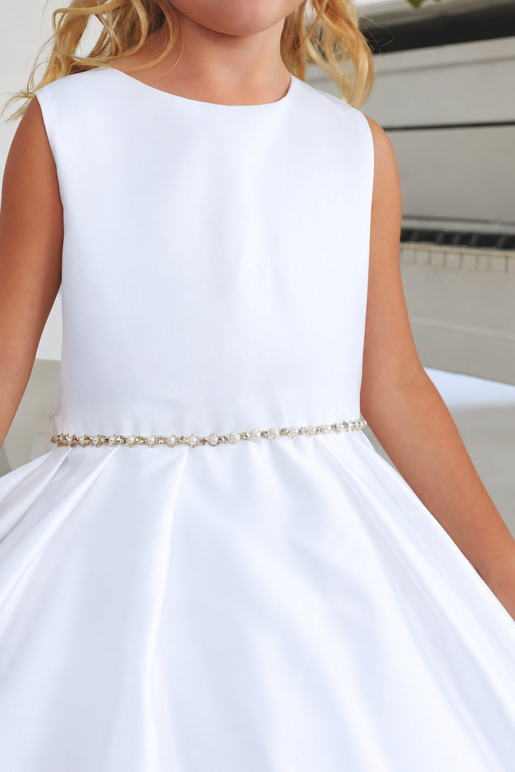 Close-up of the sleeveless satin bodice and delicate beaded waistband on Tiptop 5925 white flower girl dress.
