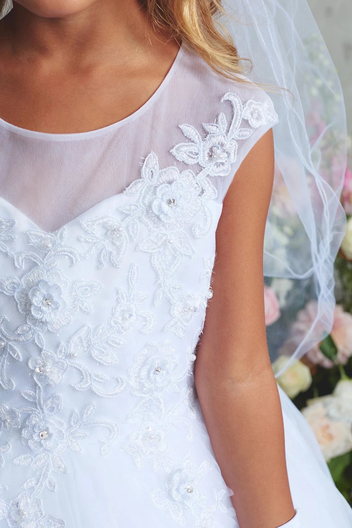 Embroidered neckline flowers accent the white flower girl dress.