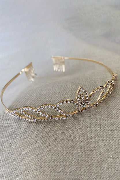 Kid Gold tiara with intricate rhinestone design on a textured surface