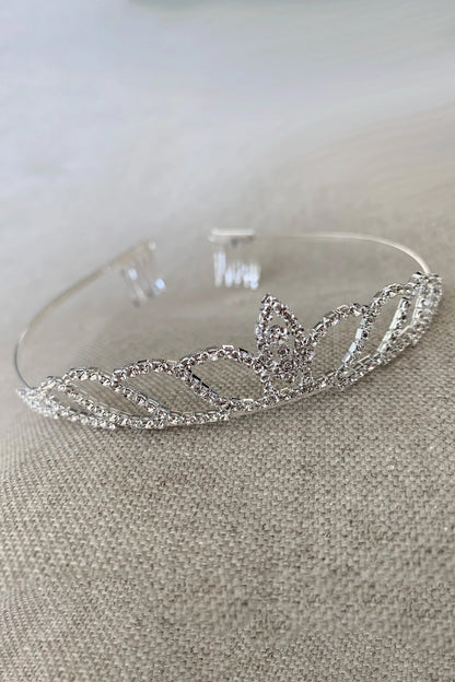 Silver kid tiara with dainty rhinestone on a neutral background
