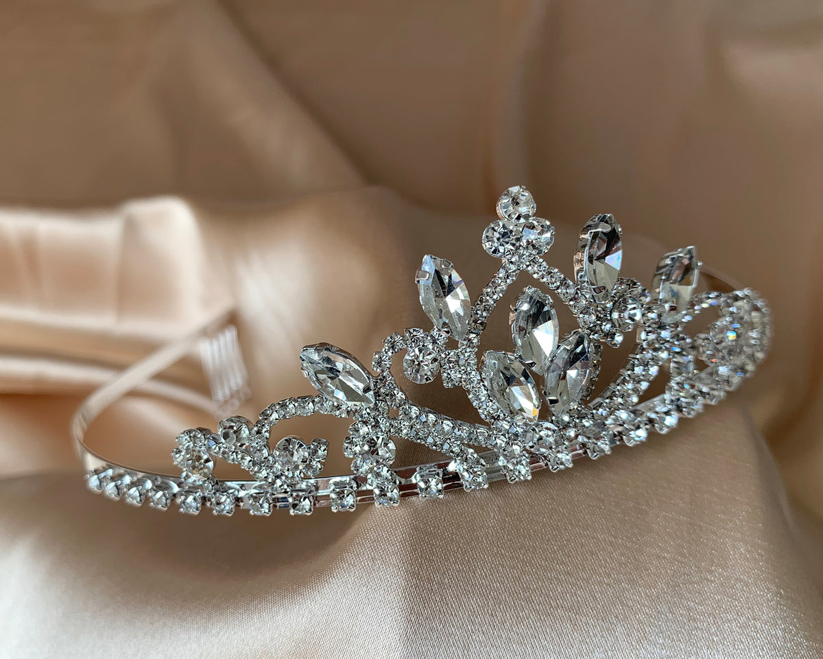 Silver rhinestone flower girl tiara, close-up, side view, embellishment detail.