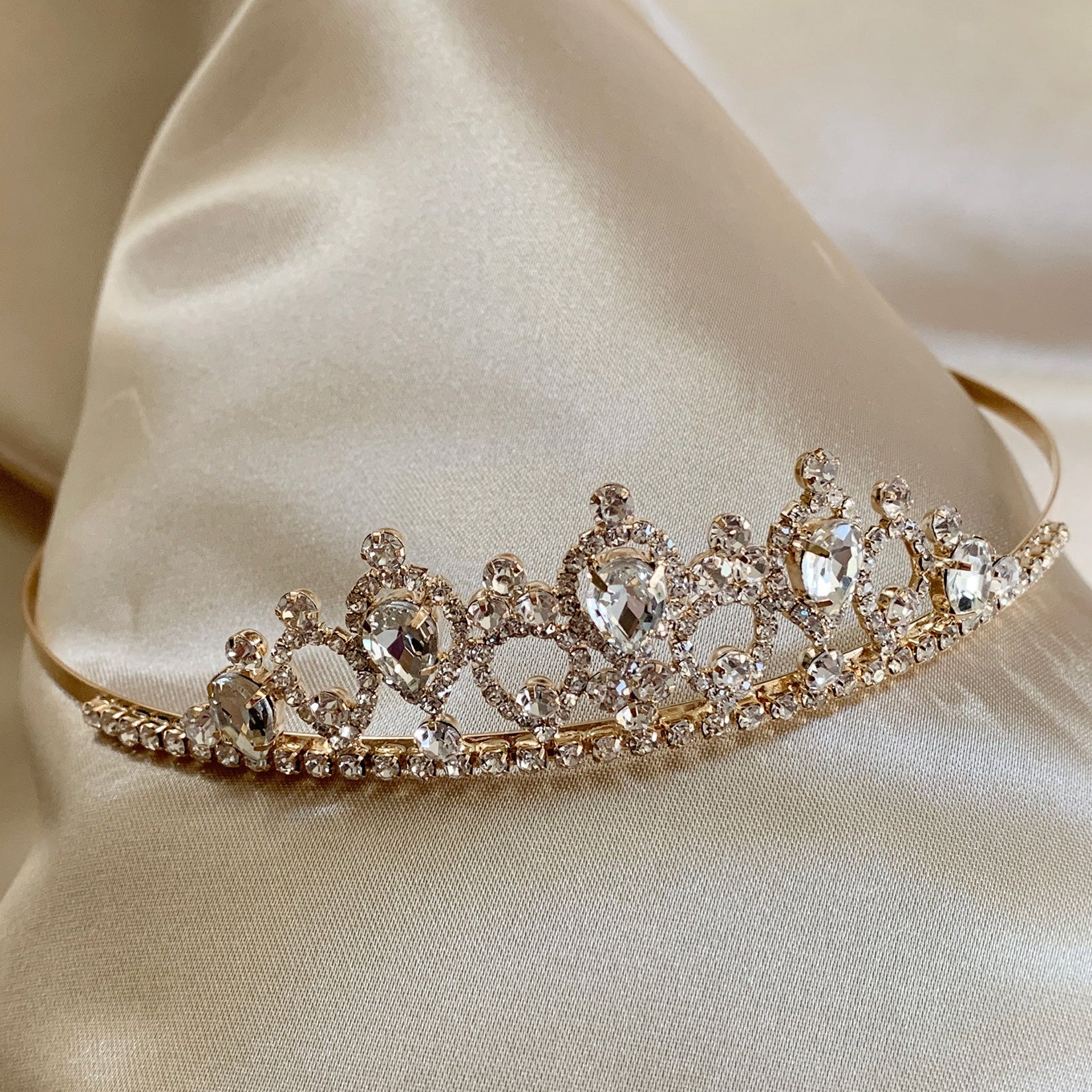 Gold rhinestone flower girl tiara, close-up, front view, embellishment detail.