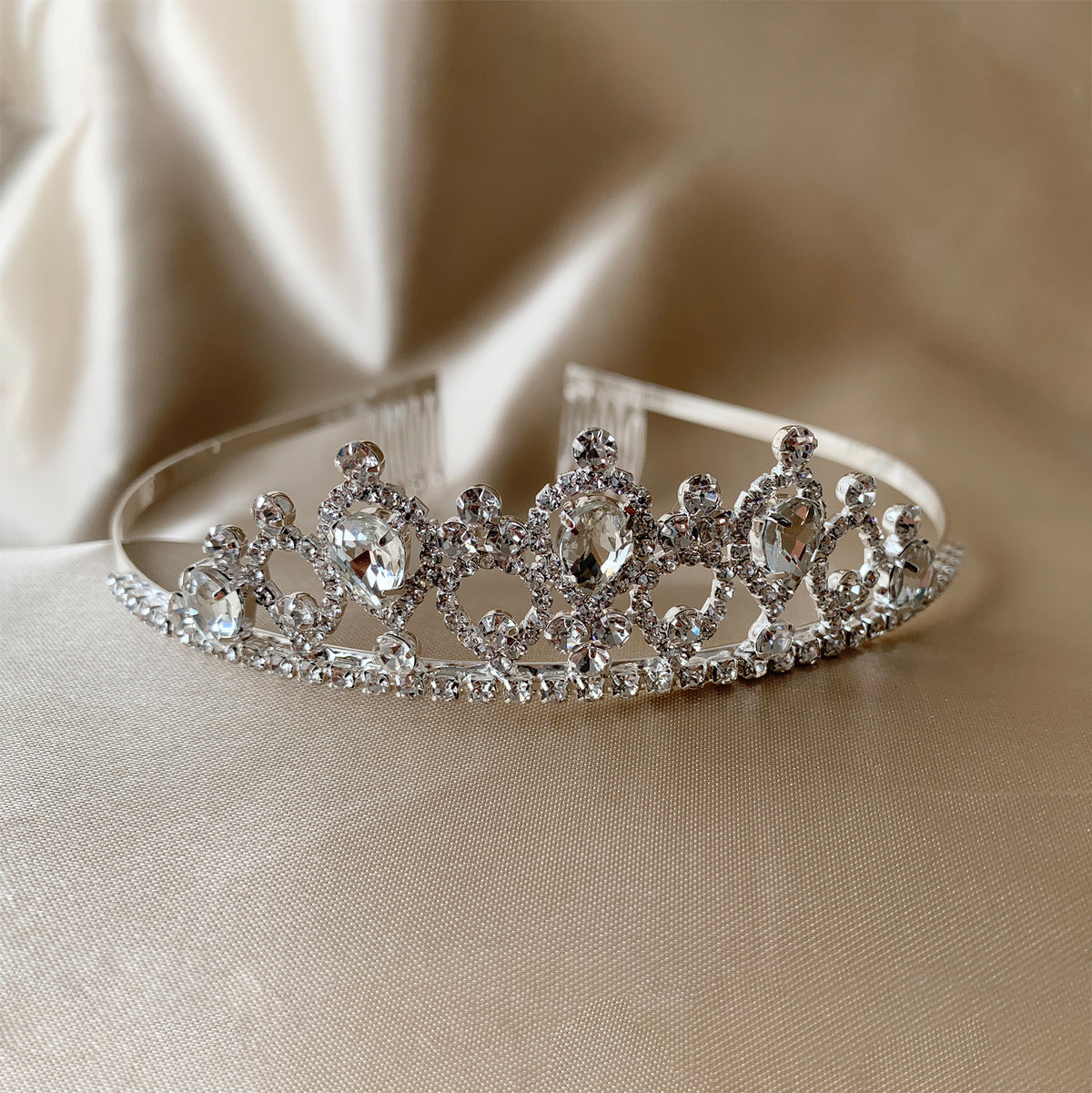 Silver rhinestone flower girl tiara, close-up, embellishment detail.