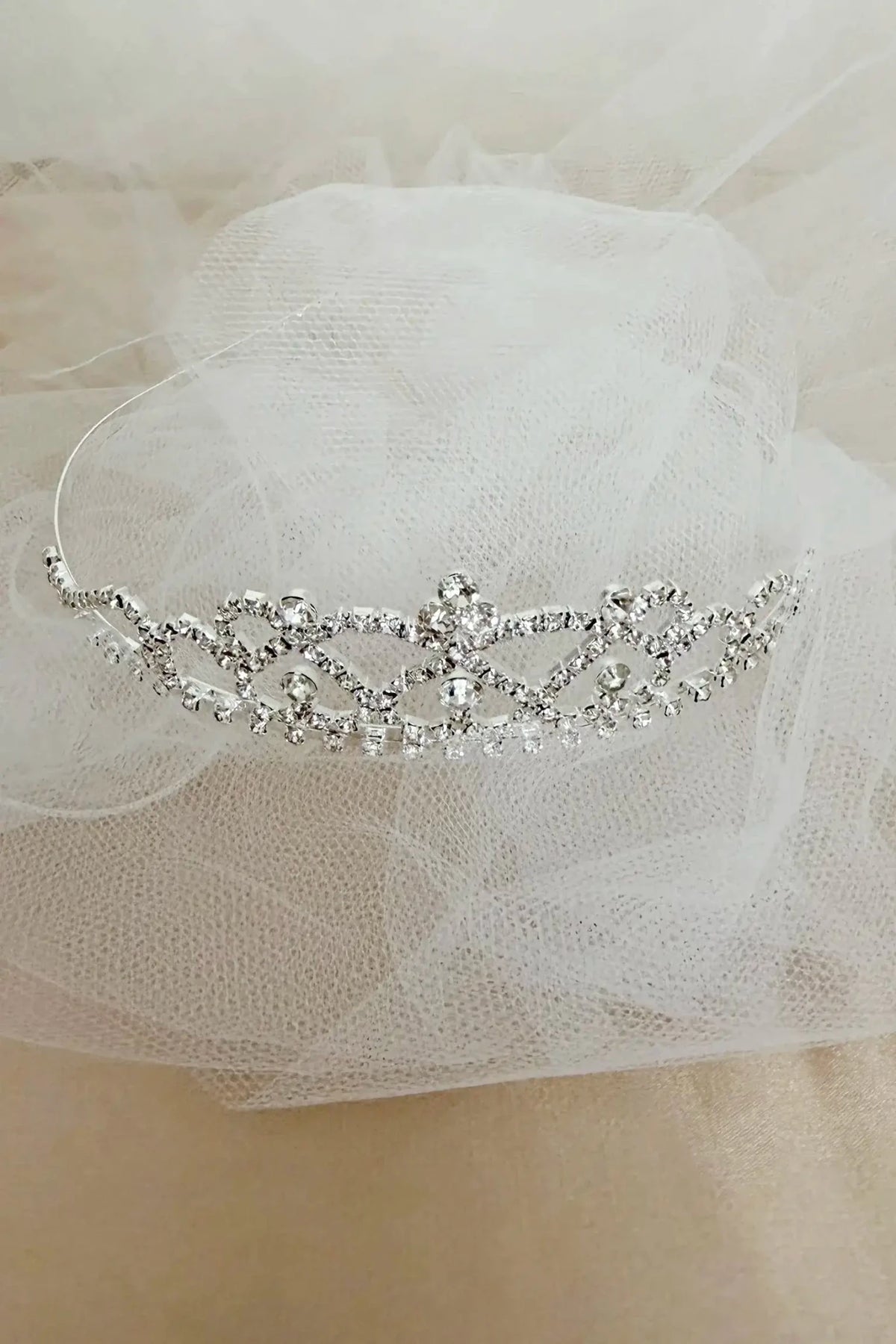 Silver rhinestone flower girl and first communion tiara and two-tier veil, close-up, embellishment detail.