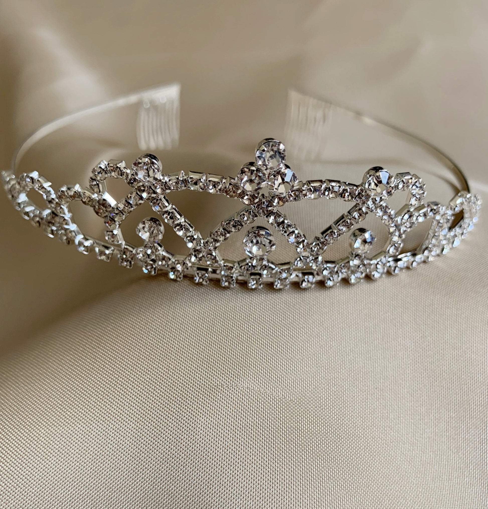 Silver rhinestone flower girl tiara, close-up, front view, embellishment detail.