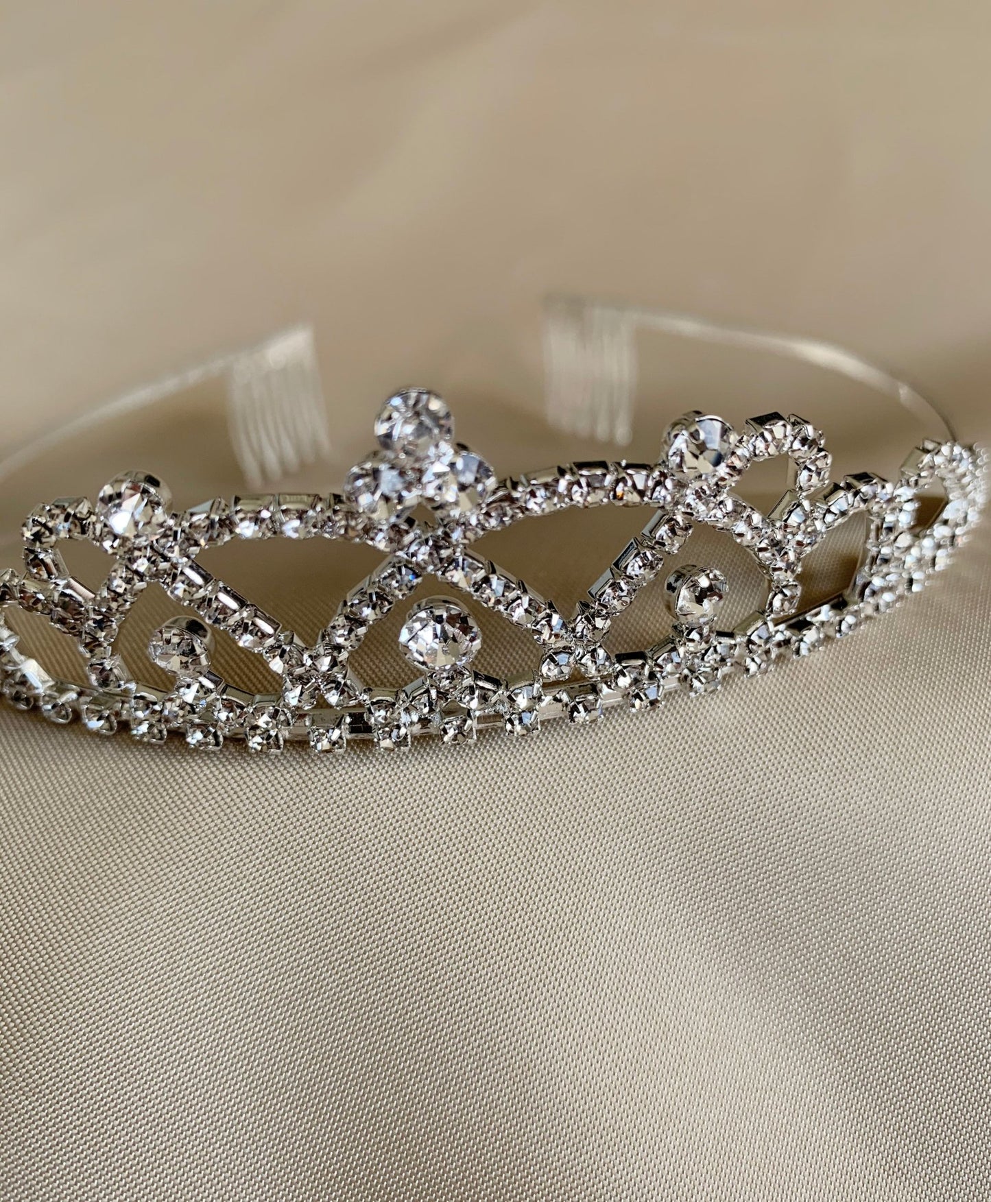 Silver rhinestone flower girl tiara, close-up, embellishment detail.