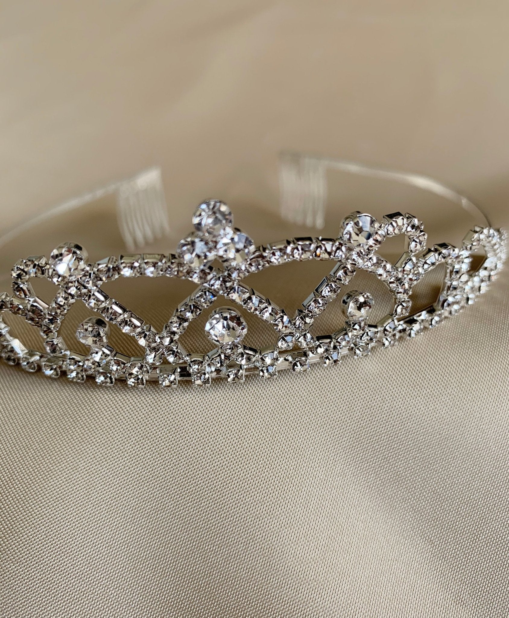 Silver rhinestone flower girl tiara, close-up, embellishment detail.
