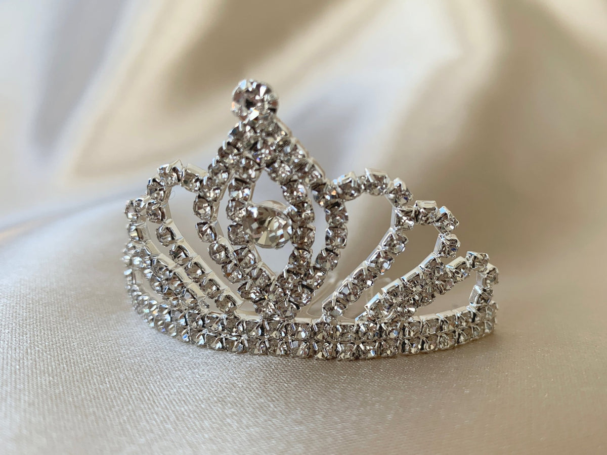 Silver rhinestone flower girl tiara comb, close-up, side view, embellishment detail.