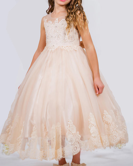 Young girl wearing a beige lace dress against a white background