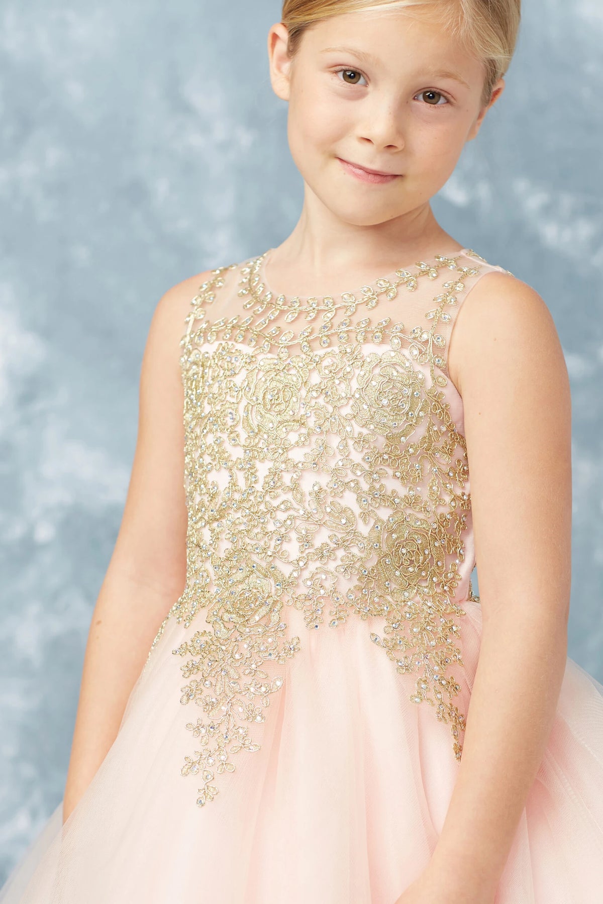 On the Blush kids pageant dress, the detailing includes gold lace across an illusion neckline.