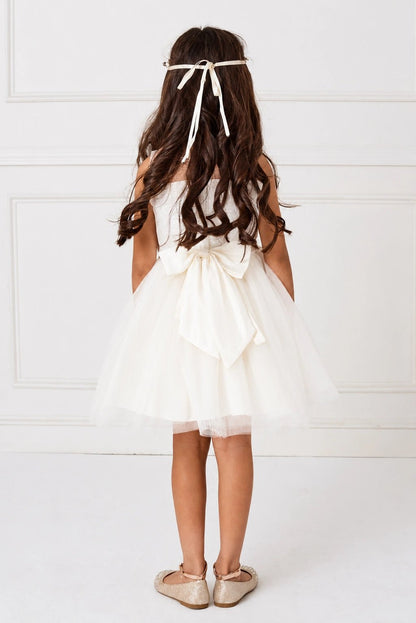 Emphasis on a layered full skirt of the off-white flower girl dress.