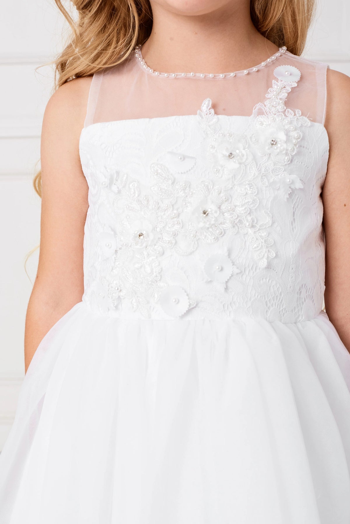 3D bodice flowers accent the white flower girl dress.