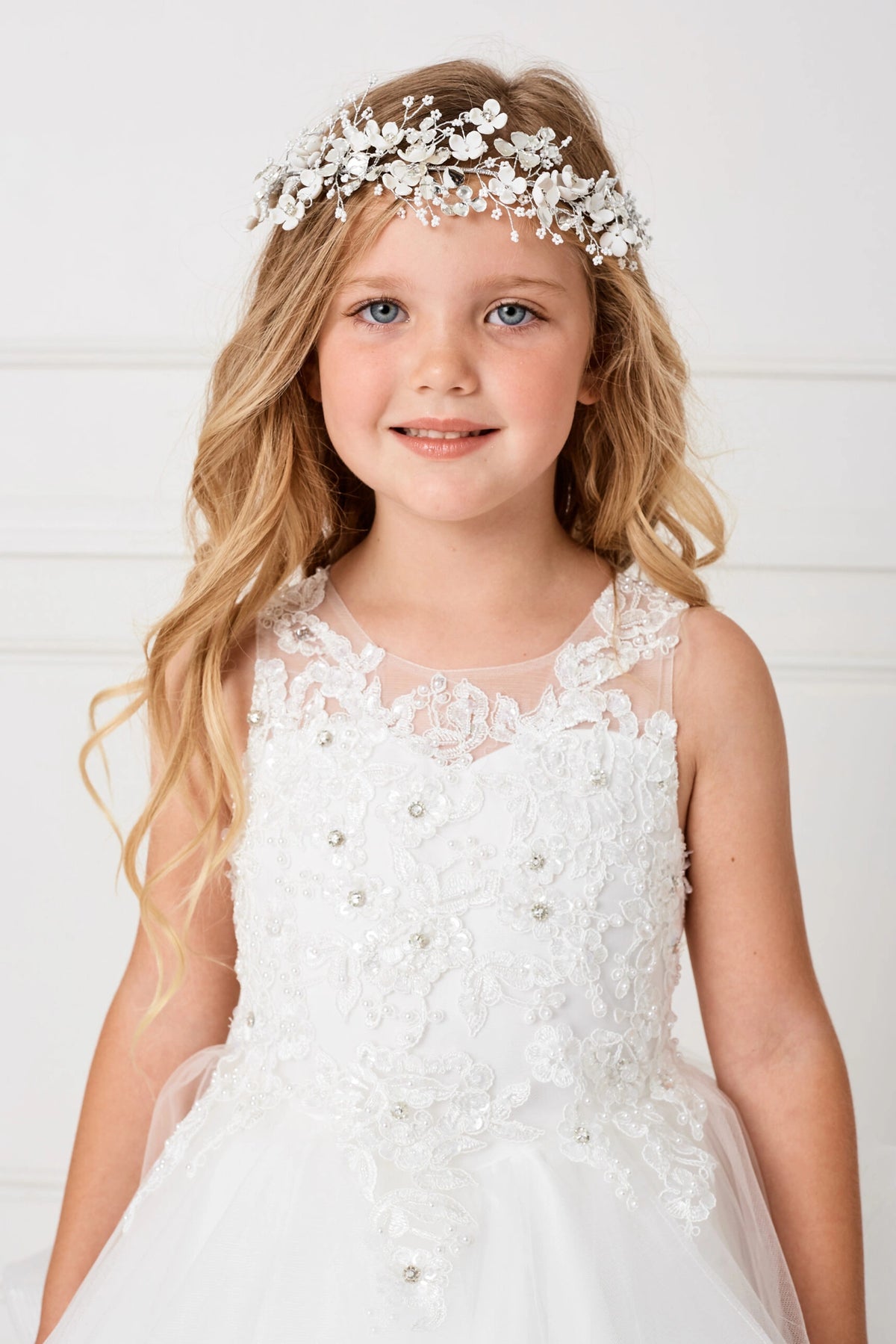 The White kids pageant dress has a floral illusion neckline.
