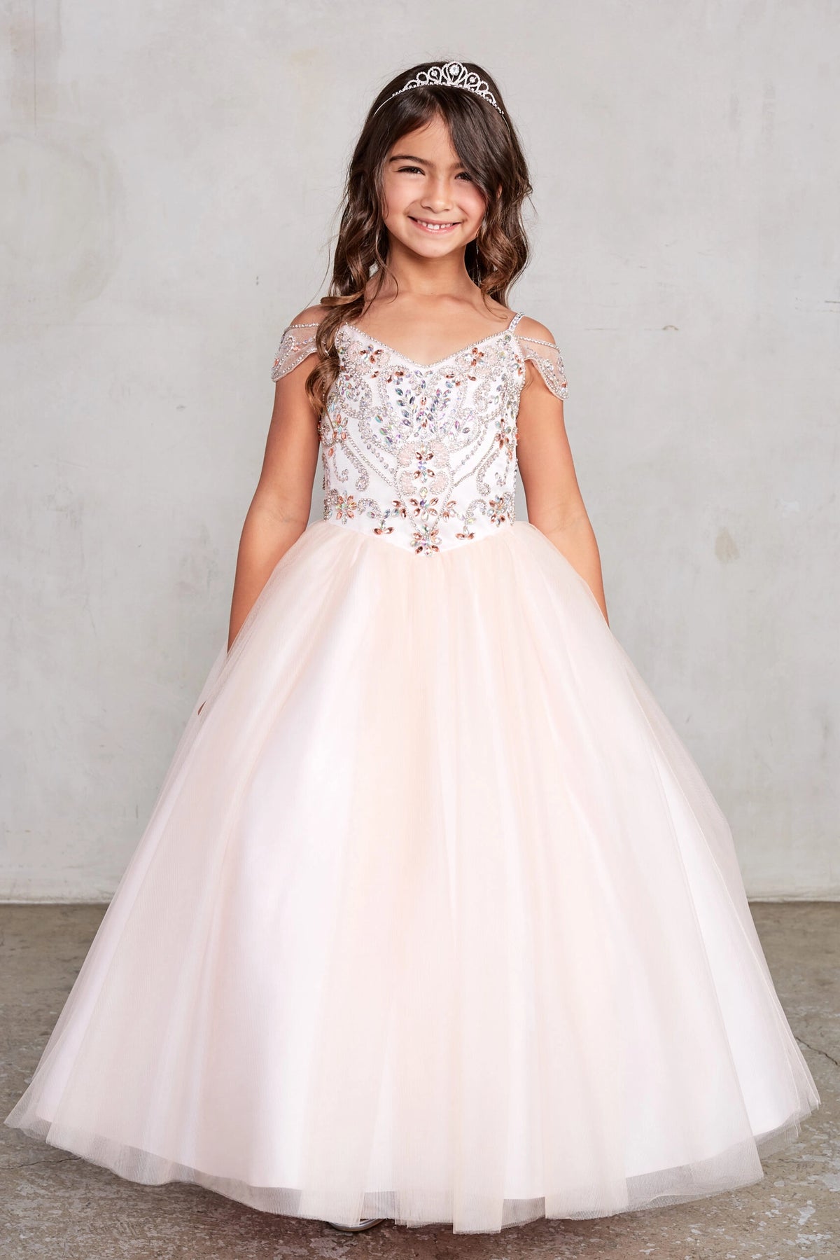 Blush kids pageant dress featuring beaded detailing around a V-neckline.