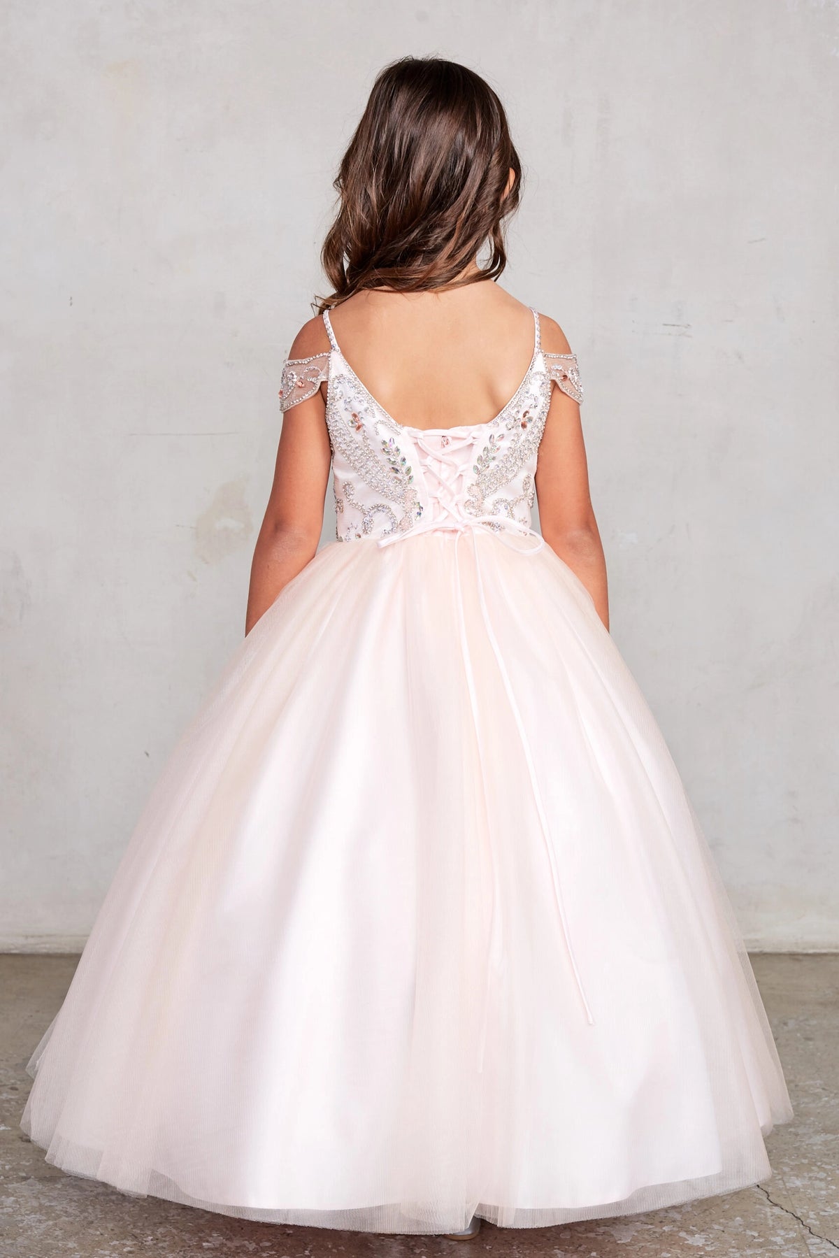 Visible details on the Blush kids pageant dress include a tied sash across the back waist.