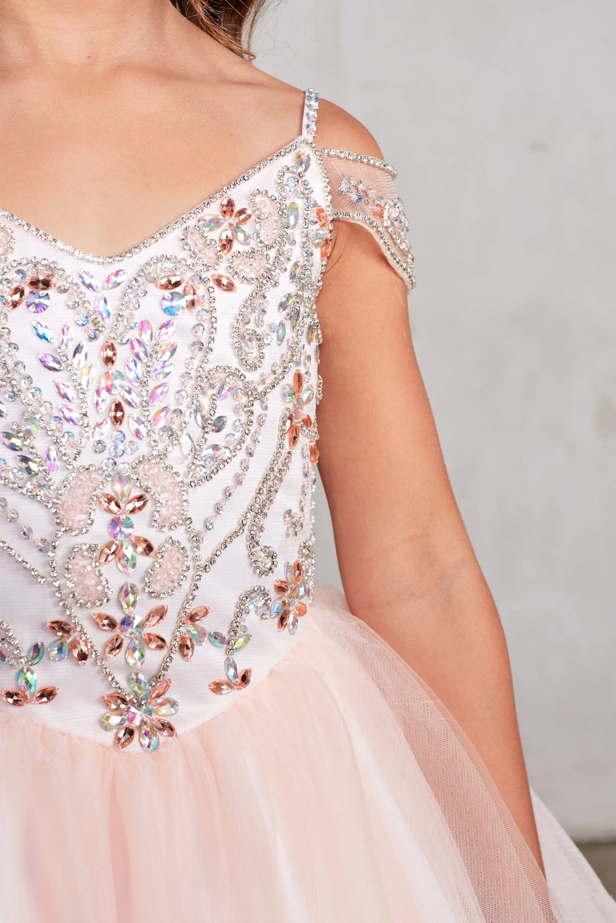 Seen from up close, this Blush kids pageant dress displays rhinestone detailing at the V-neckline.