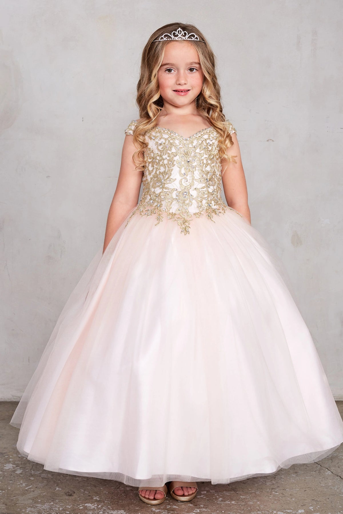 Blush kids pageant dress featuring gold floral lace on the bodice.
