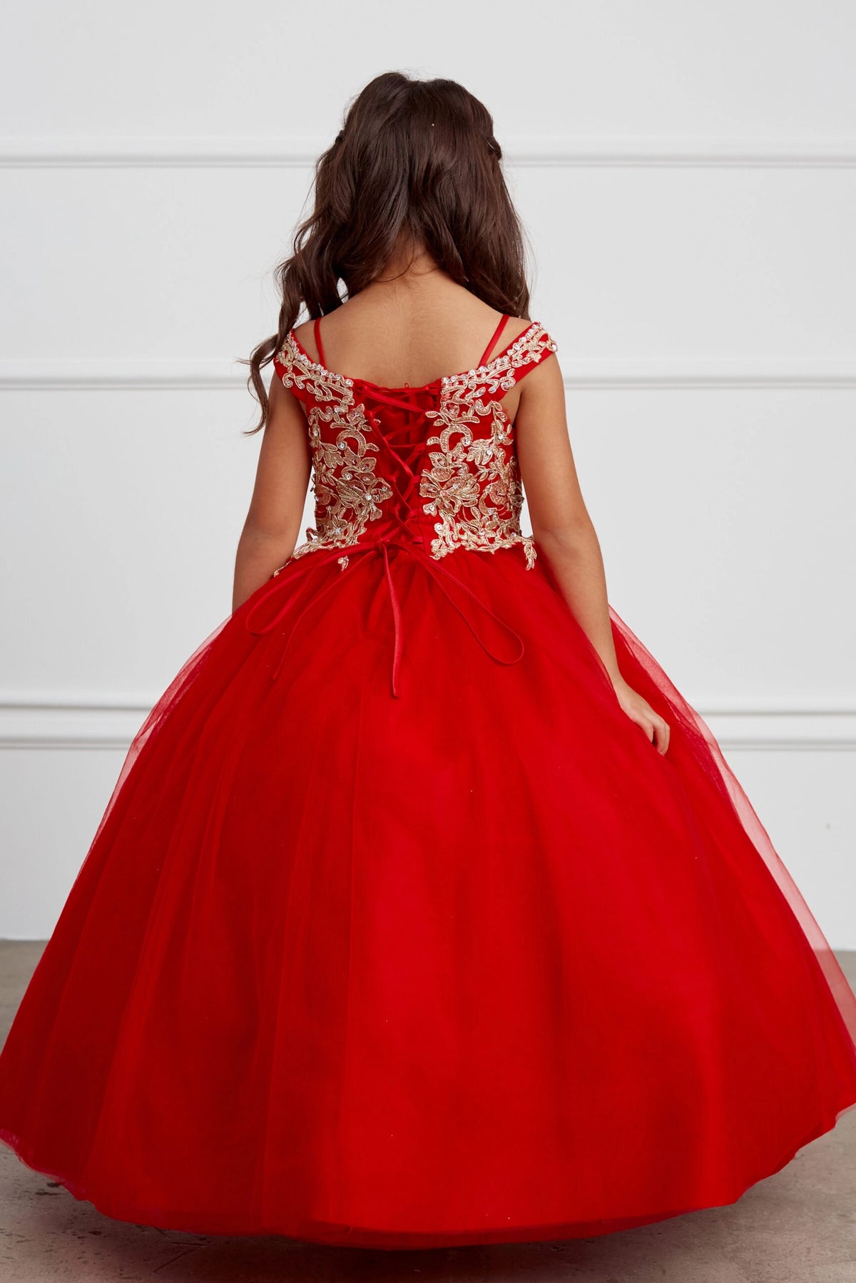 The Red kids pageant dress has gold floral lace on the bodice.