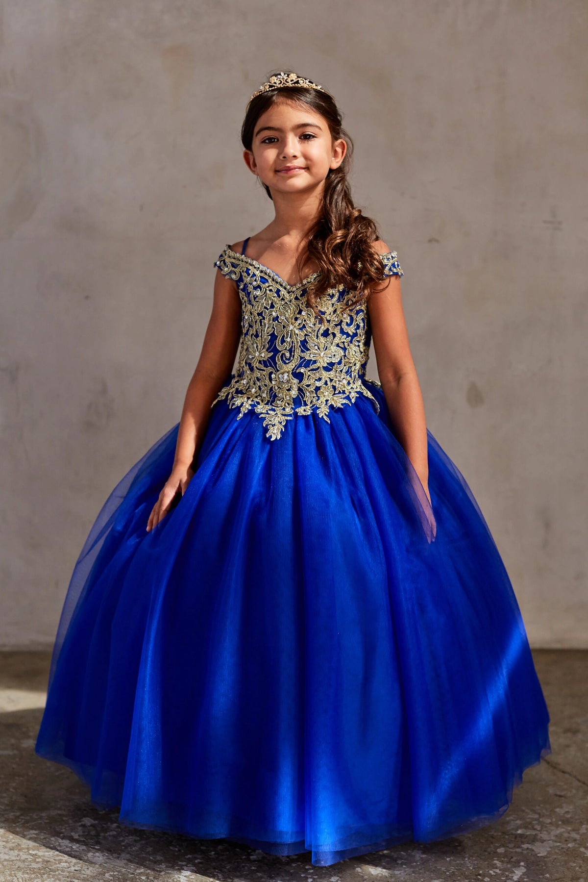 The Royal Blue kids pageant dress has gold floral lace on the bodice.