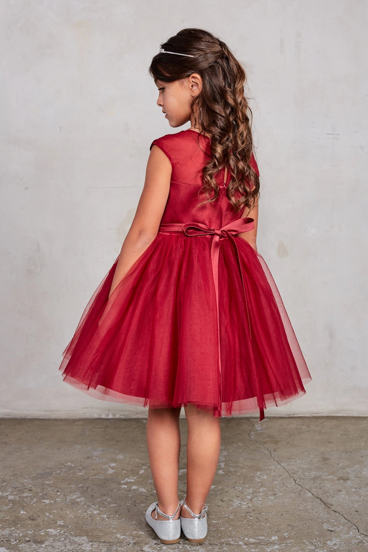 The Burgundy kids pageant dress has a tied sash across the back waist.