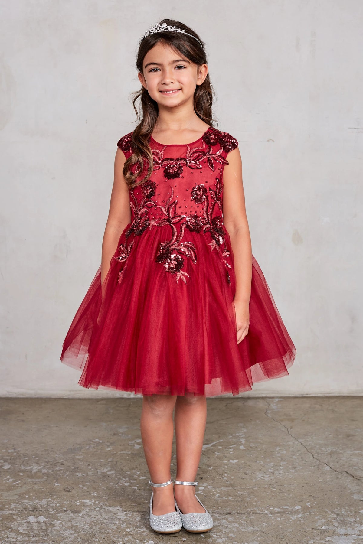 On the Burgundy kids pageant dress, the detailing includes sequin floral embroidery.