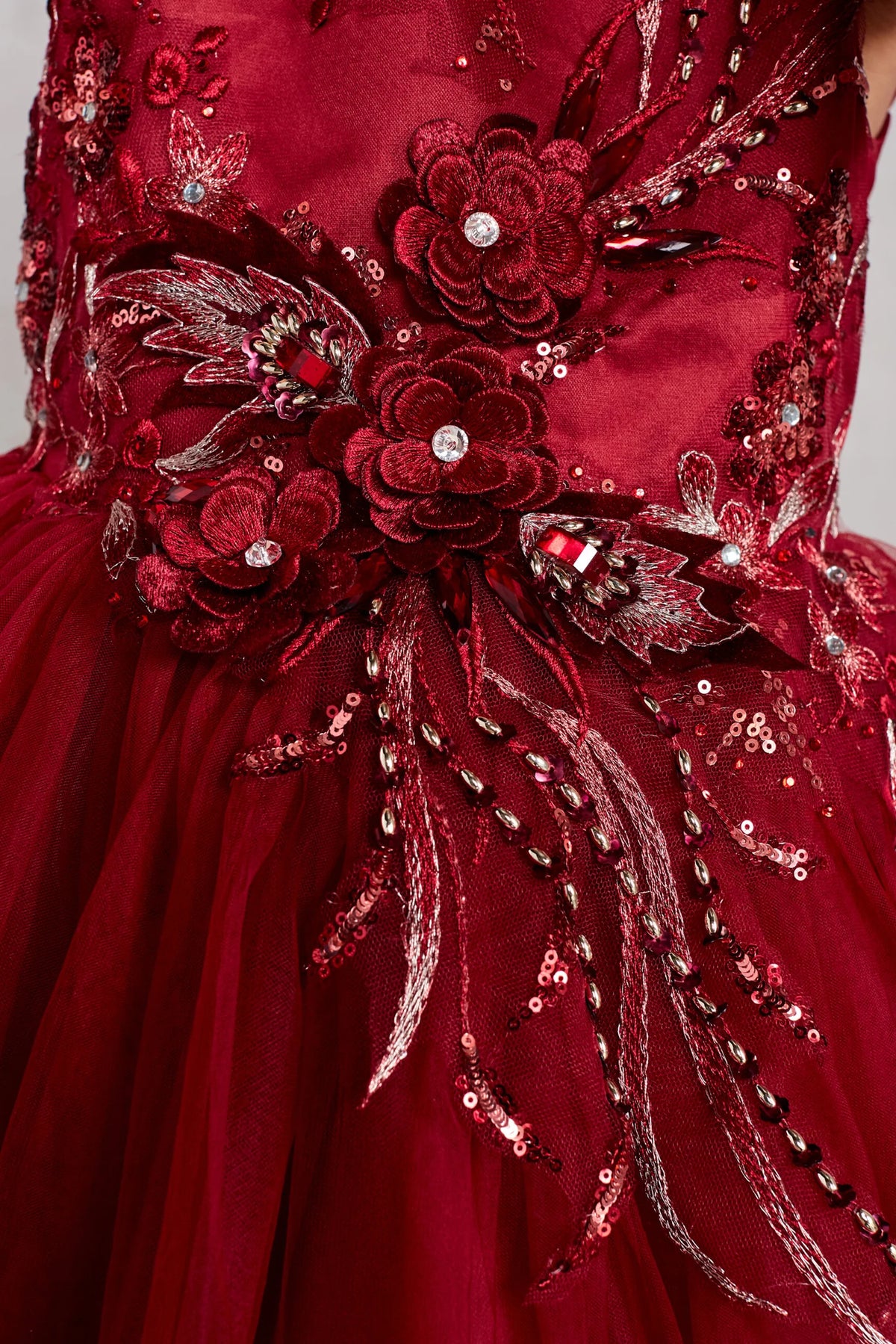 The Burgundy kids pageant dress has dimensional flowers and rhinestones.