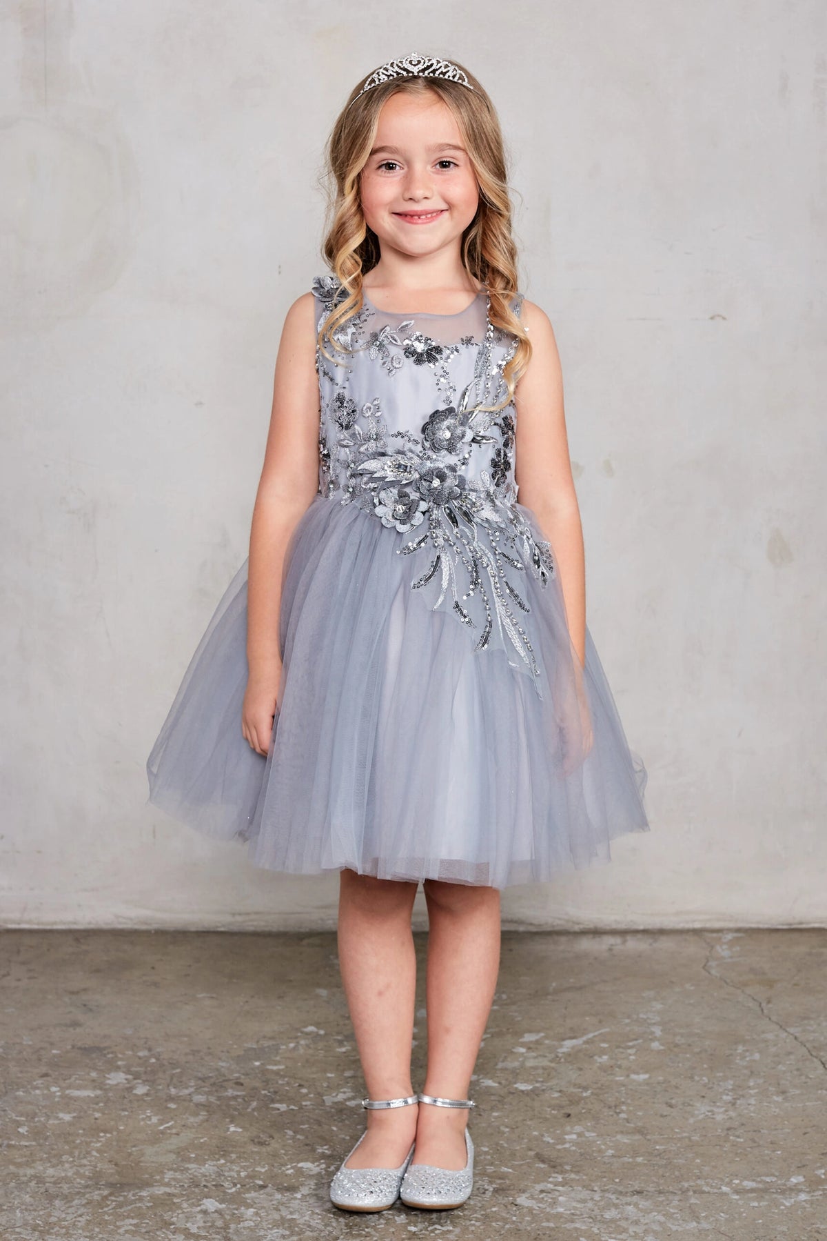 Silver kids pageant dress featuring dimensional floral embellishments.