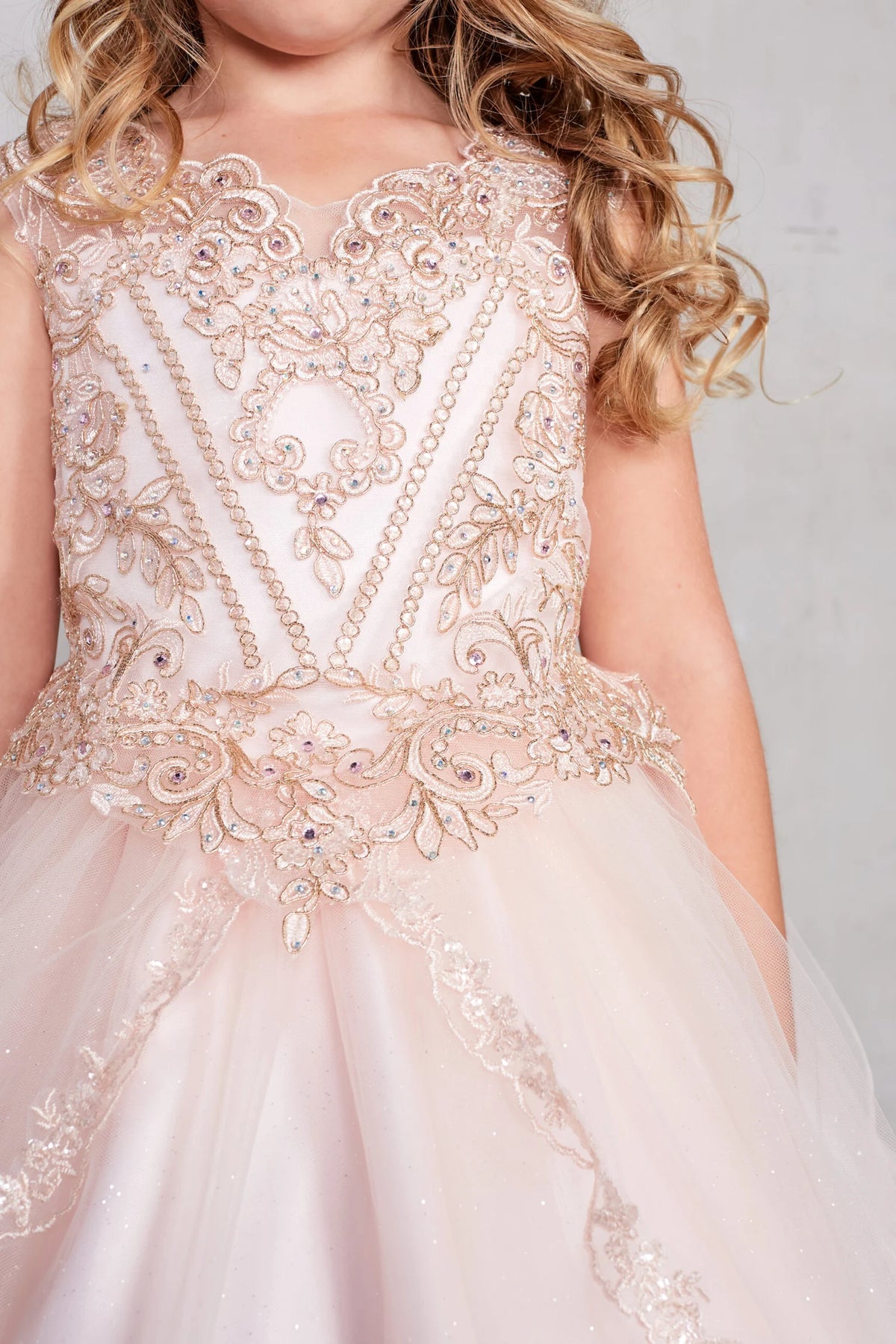 The Rose Gold kids pageant dress has metallic lace and rhinestones.