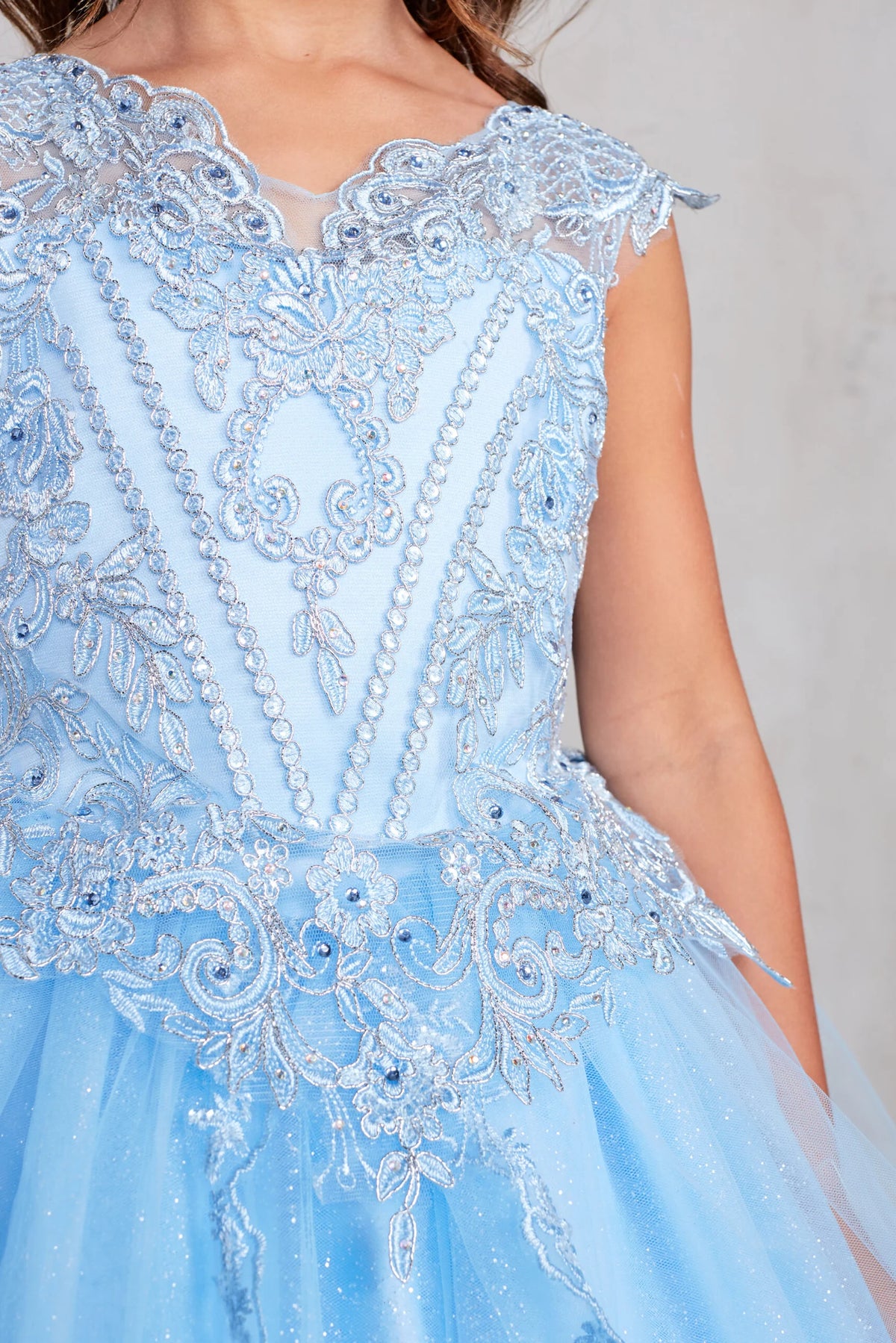 Seen from up close, this Sky Blue kids pageant dress displays corded lace and rhinestones at the waist.