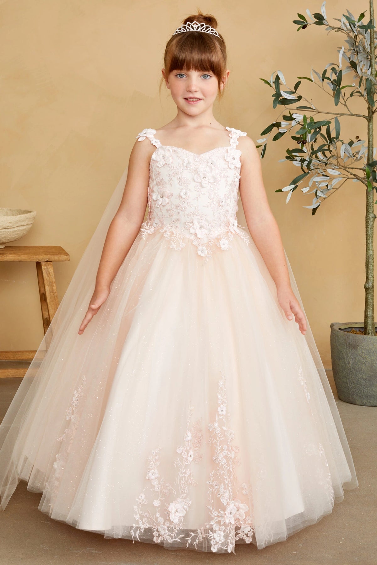Blush kids pageant dress featuring floral appliques on a full tulle skirt.