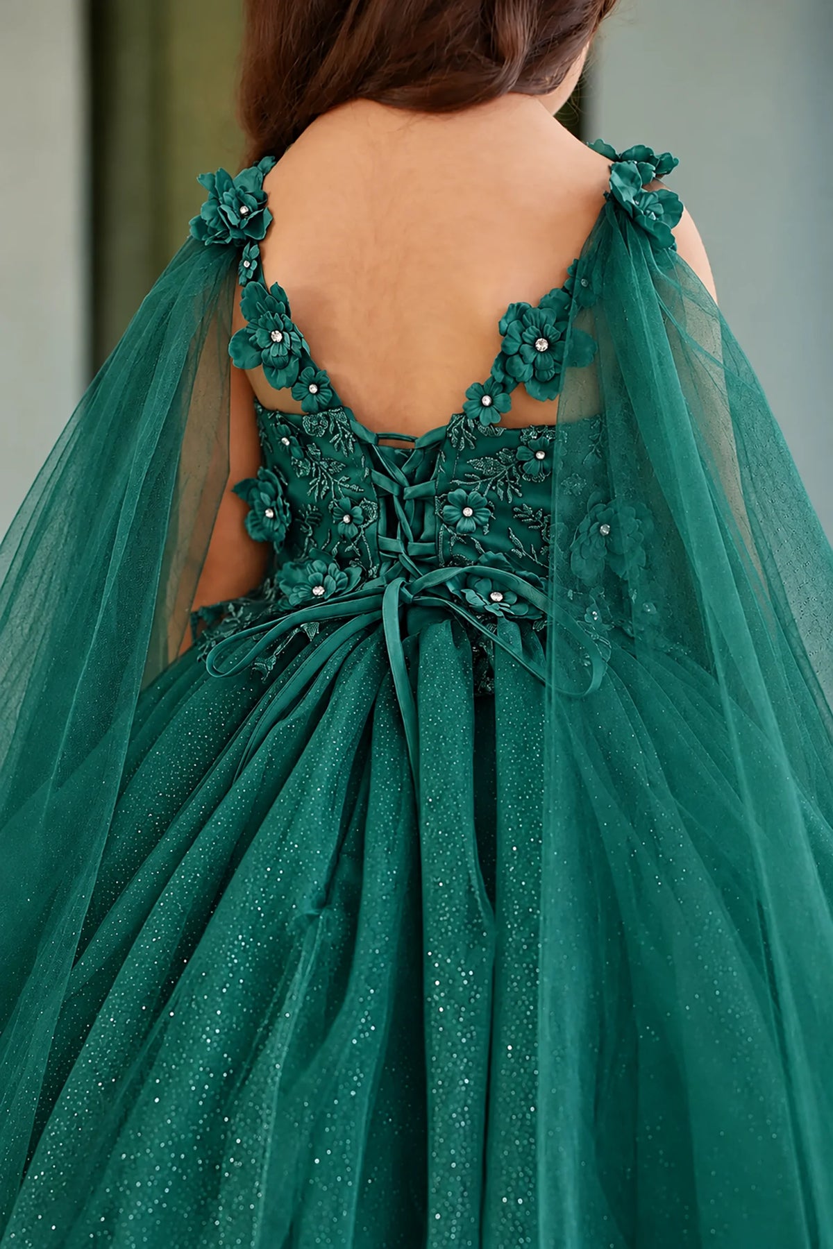 Crisscross lacing secures the Hunter Green (Emerald) mini quince dress beneath floral back trim.