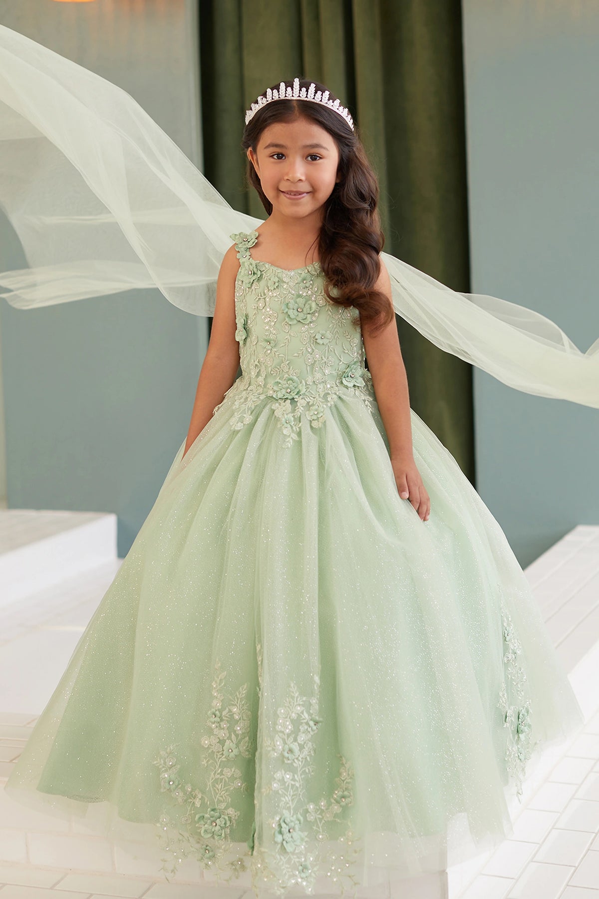 Visible details on the Sage kids pageant dress include lace-up ties beneath the cape.