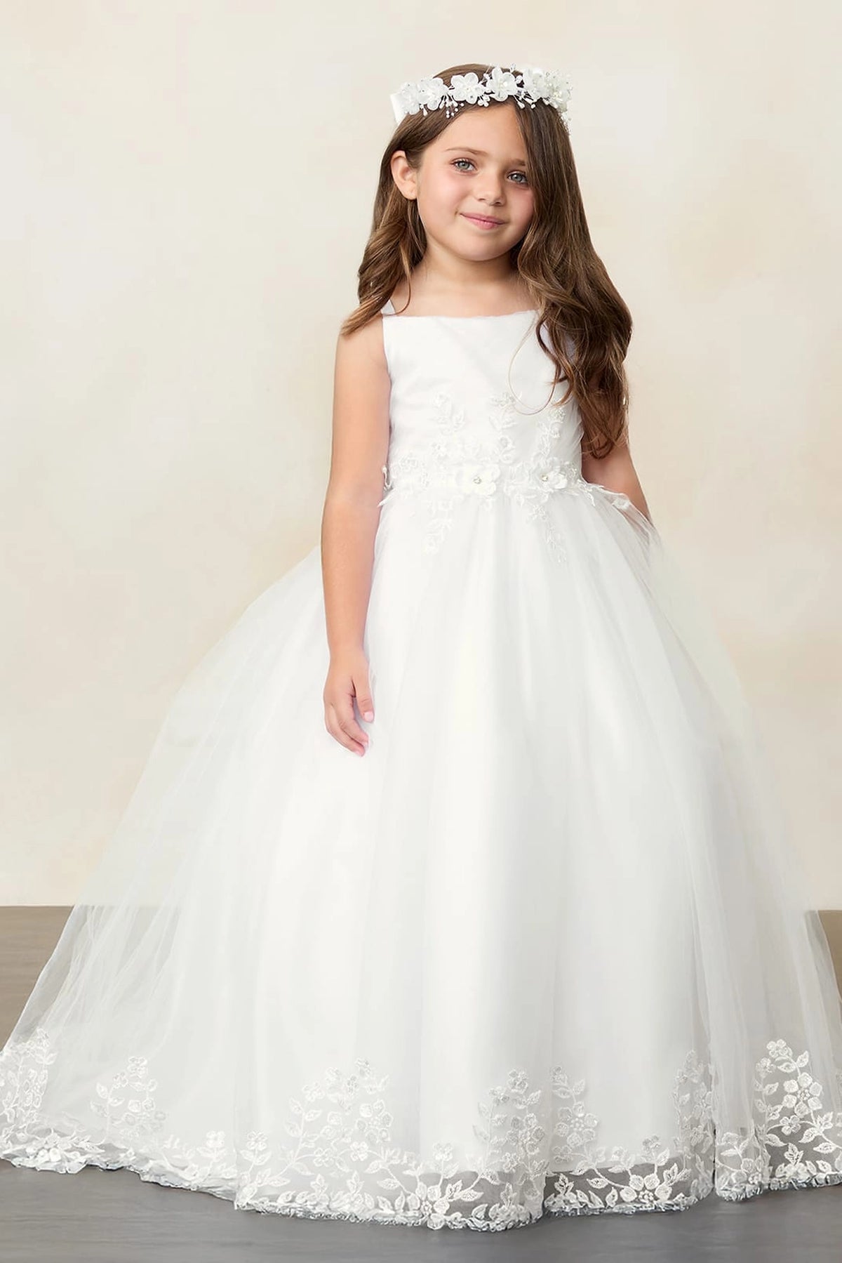 Ivory kids pageant dress featuring lace trimming along a flowing train.