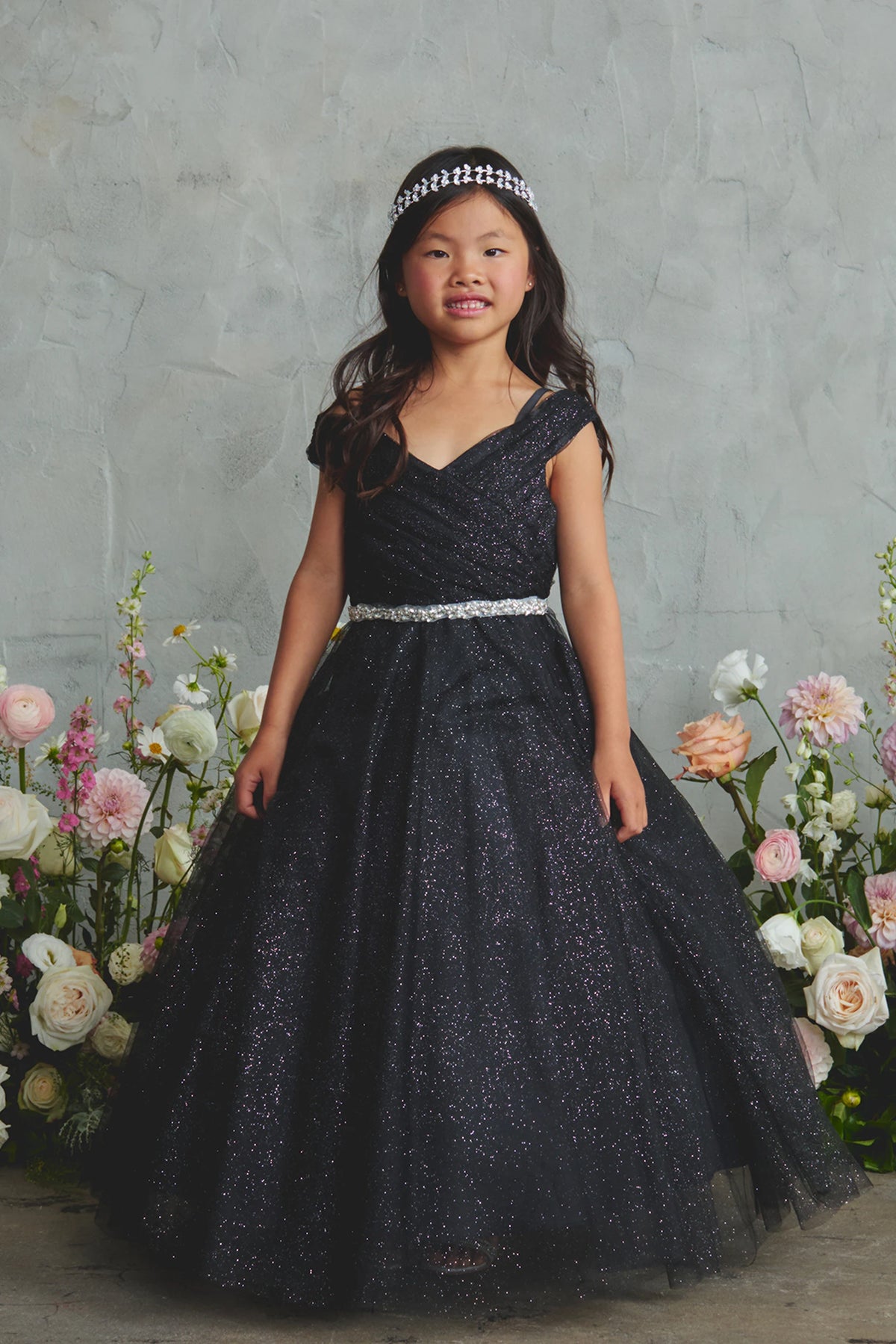 The Black kids pageant dress has an asymmetrically pleated neckline.
